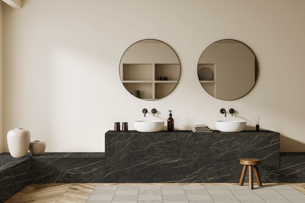 Beige bathroom interior with double sink and round mirror, stool on carpet, hardwood floor. Hotel bathing accessories and art decoration. 3D rendering
