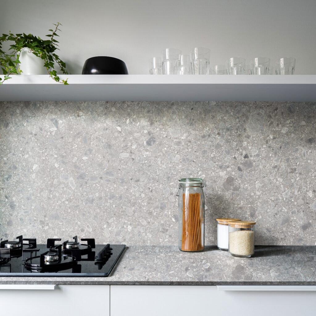 Simple kitchen with gray countertop and backsplash wall and white furniture