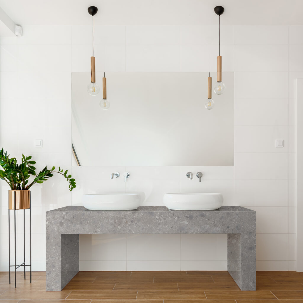 Luxury white bathroom with big mirror above two washbasin and wooden floor